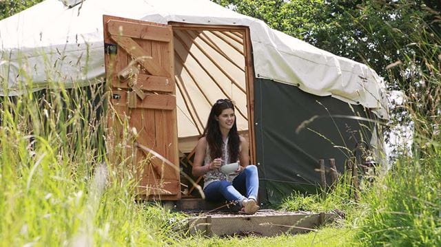 Glamping guide woman sitting outside tent